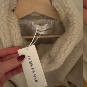 Beige teddyjacka från Carin Wester - Supermjuk och oversized teddyjacka från Carin Wester i beige. Jackan har hög krage, dragkedja framtill och stora fickor.  Jackan är ny, inte använt sen jag köpte den❤️