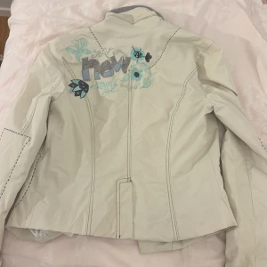 JACKA FRÅN DESIGUAL - Fin vårig/höstlig jacka från desigual! Skön insida med fleece material vid händerna vilket är perfekt för lite kyligare väder. Fin broderad design på ryggen! 