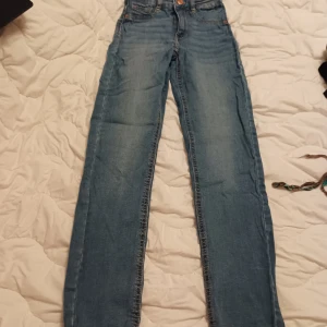 Blå Molly jeans från Perfect Jeans XS - Snygga blå Molly jeans från Perfect Jeans i storlek XS. Jeansen har klassisk femficksdesign, hög midja och raka ben. Tillverkade i mjukt denim med ljus tvätt och detaljer i kopparfärgad metall. Perfekta för en avslappnad och trendig look.