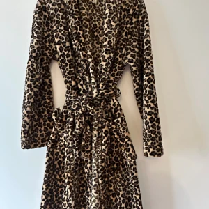 Leopardmönstrad morgonrock från Holly & Whyte - Säljer en supermjuk och fluffig morgonrock från Holly & Whyte i storlek S. Morgonrocken har leopardmönster, bälte i midjan och långa ärmar. 