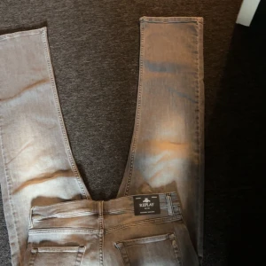Grå jeans från Replay, storlek 14A - Säljer ett par grå jeans från Replay i storlek 14A. Jeansen har fem fickor, klassisk passform och snyggt tvättad look med ljusa partier. Märkeslapp bak i midjan och dragkedjegylf. Perfekta för dig som gillar stilrena och bekväma jeans.