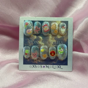 CandyXmas(M);Short Oval - Handgjorda press-on naglar med silverglittrig transperant bas och söta julmotiv som tomte, pepparkaka, polkagris, cupcake och godis. Naglarna har kort oval form och färgglada dekaler i rött, grönt, vitt och gult. Perfekt för dig som vill ha en lekfull och festlig look.