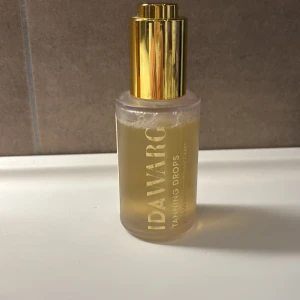 Ida Warg Tanning Drops - Tanning Drops från Ida Warg i en genomskinlig glasflaska med guldig pump. Perfekt för att ge ansiktet en solkysst look. Dropparna är veganska och parfymfria, och blandas enkelt med din vanliga hudvård.