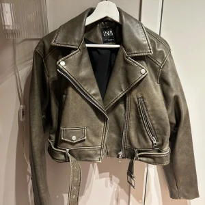 Skinnjacka Zara, S - Snygg olivgrön skinnjacka från Zara i bikerstil. Sedd på Molly Mae. Jackan är croppad och något boxig modell. Sparsamt använd, mest hängt i garderoben så är i superfint skick.