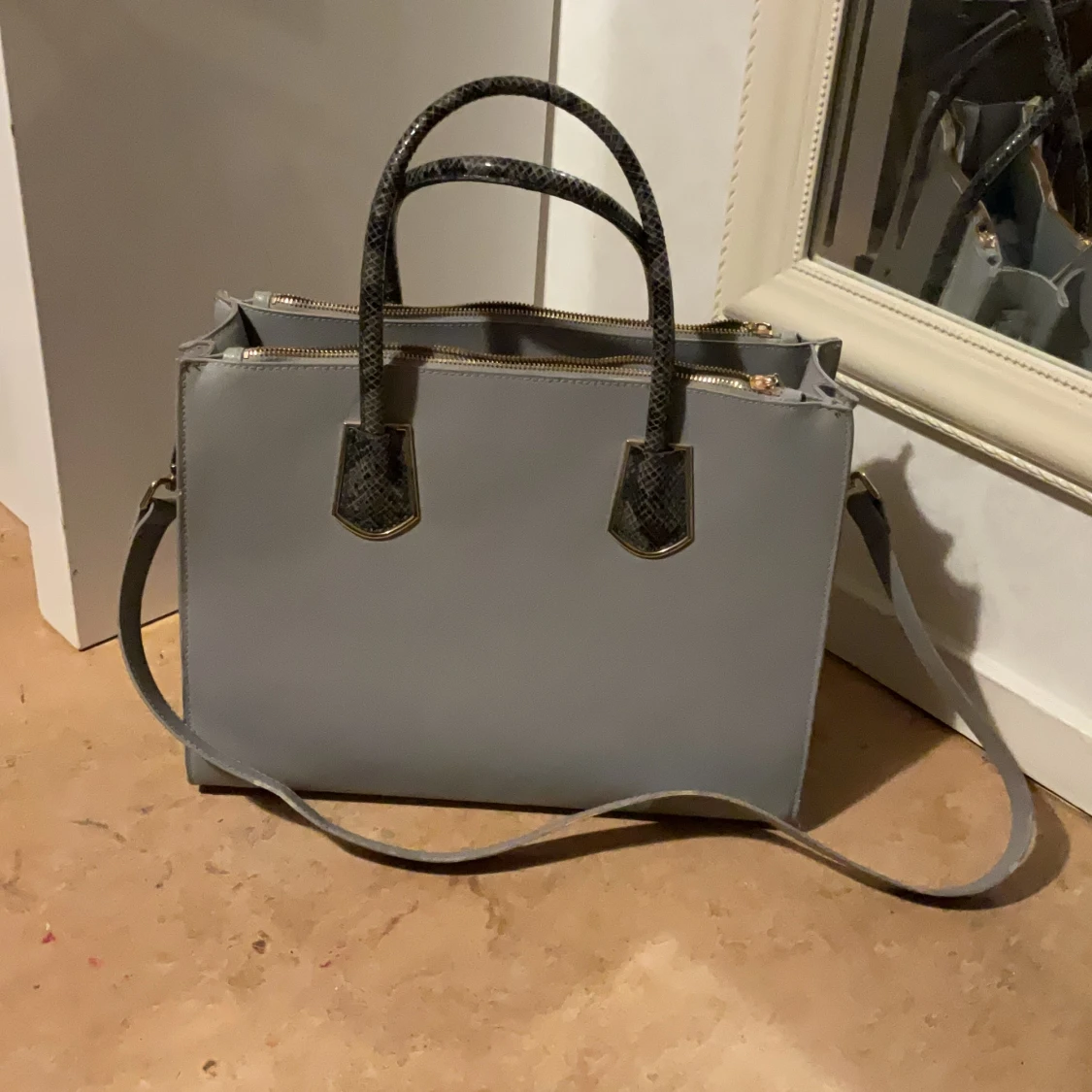 Grå axelväska med ormmönstrade handtag