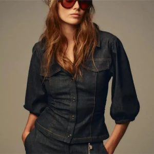 Mörkblå jeansblus från Zara - Trendig mörkblå jeansblus från Zara med markerade sömmar, trekvartsärmar med resår och snygga bröstfickor. Skjortan har figurnära passform, klassisk krage och knäppning framtill. Perfekt för dig som gillar en cool denimlook. Endast testad!!💓💓