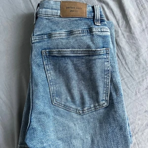 Blå bootcut jeans från Gina Tricot - Säljer ett par ljusblå bootcut jeans från Gina Tricot. Normal passform och tillverkade i mjukt jeanstyg.