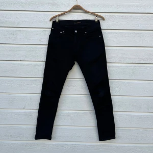 Nudie Jeans Slim Fit 29/30 - Hej! Säljer nu mina svarta Nudie Jeans. De är i fint skick är i storlek W29 L30, med passformen slim fit. Nypris: 1600 kr. Hör av dig om du undrar något! 