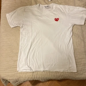 Vit Cdg Play t shirt  - Riktig fet Cdg play t shirt! Storlek är M men passar bättre på S. Inköpt på Nk 800kr. Toppenskick!