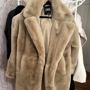 Beige pälsjacka från Zara - Supermjuk och fluffig beige pälsjacka från Zara med bred krage och helfodrad insida.