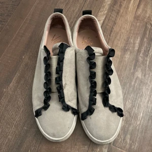 Grå sneakers med volang  - Jätte snygga coola sneakers, väldigt unika och passar fint till varje outfit ! 