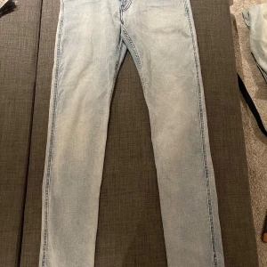 Replay Anbass ljusblå jeans 30/32 - Säljer ett par Replay Anbass jeans i ljusblå tvätt med klassisk femficksdesign och snygga bakfickor med broderad detalj. Jeansen har smal passform och är tillverkade i mjukt denimtyg som sitter skönt hela dagen.