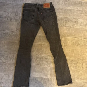 Levi's 511 svarta skinny jeans W28 L32 - Svarta Levi's 511 jeans med skinny passform och klassisk femficksdesign. Jeansen har en snygg tvättad look, knapp och dragkedja fram samt Levi's ikoniska läderpatch bak i midjan. Perfekta för dig som gillar en smal siluett och tidlös stil.