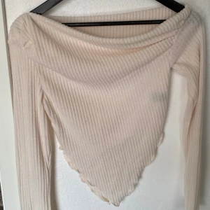 Beige ribbad offshoulder topp Shein - Säljer en beige ribbad offshoulder topp från Shein i storlek M. Toppen har lång ärm och en spetsig nederkant framtill som ger en snygg siluett. Tillverkad i mjuk och stretchig polyesterblandning, perfekt för att lyfta din outfit.