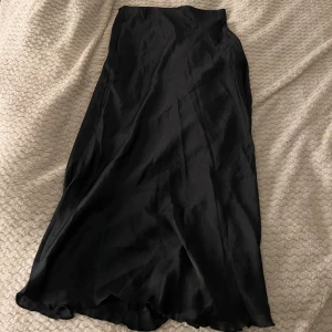 Svart långkjol från lager 157 - Säljer en svart långkjol i satin från lager 157, med diskret dragkedja i sidan🥰