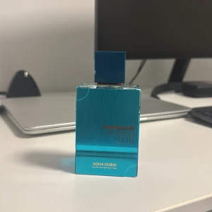 Haramain Amber Oud Aqua Dubai - Trendig parfym med modern känsla. Flaskan rymmer 75 ml och har en snygg blå design. Perfekt för dig som vill sticka ut med något unikt. Extrait de Parfum ger extra intensitet.