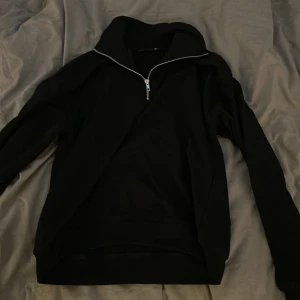 Svart half zip hoodie från 157 - Svart hoodie från 157 med halv dragkedja och hög krage. Klassisk och enkel design med lång ärm och mjukt material, perfekt för lager-på-lager och inför hösten💕