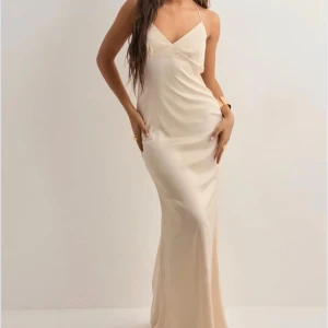 Champangefärgad balklänning  - Säljer min champagnefärgade balklänning med smala axelband och v-ringning framtill. Man kan välja helt själv hur ryggen ska vara vilket är helt perfekt! 😍😍😍Klänningen är i nyskick och använd endast 1 tillfälle!! 