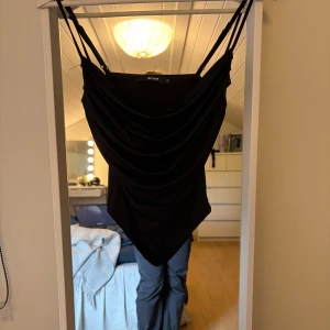 Svart draperad topp  - Supersnygg svart kort klänning från BikBok med draperad framsida och tunna justerbara axelband. Har likadan i mörkgrön också om intresse finns!🖤Aldrig använd!