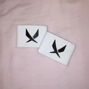 SOC Benskyddshållare vitt/svart - Säljer ett par benskyddshållare från SOC. De är helt nya och oanvända. Som du ser på bilden så är de justerbara.