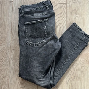 Replay svarta jeans - Svarta jeans från Replay med riktigt snygga slitningar. Modellen är Anbass och dom är i strl W32 L30. Det finns ett litet hål i byxorna (se ovan) därav nedsatt pris. Tveka inte på att höra av dig om du har frågor!