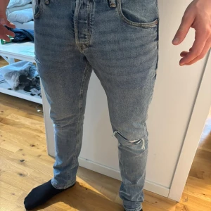 Jack & Jones ljusblå skinny jeans 31/30 - Säljer ett par ljusblå  jeans från Jack & Jones i storlek 31/30. Jeansen har klassisk femficksdesign, slitningar vid knäet och smal passform. Materialet är jeans med snygga kontrastsömmar och autentisk tvättad look.