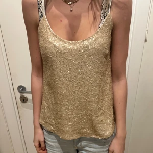 Guldig paljettlinne - Säljer ett glittrigt guldigt linne med paljetter.