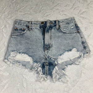 Högmidjade short från Bershka  - Snygga högmidjade jeansshorts från Bershka i ljusblå denim. De har slitna detaljer, fransig kant och klassisk femficksdesign. Skriv för flera bilder 🥰