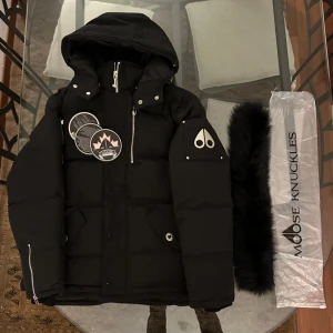 Svart pufferjacka Moose Knuckles - Säljer en svart pufferjacka från Moose Knuckles i storlek M. Jackan är i fint skick. Säljer den eftersom den är lite för liten för mig. På sista bilden är det en bild på jag, jag är 183 cm lång och väger 77 kg, där sitter jackan tight redan med bara en hoodie under. Pris kan diskuteras 