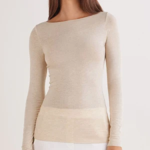 Beige långärmad topp i ullmix - Snygg beige långärmad topp med rund halsringning och figurnära passform. Tillverkad i tunn och mjuk ullmix som känns skön mot huden. Perfekt att styla med jeans eller kjol för en clean och enkel look.