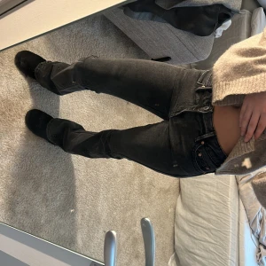 Svarta jeans från ginatricot 32 - Grå/svarta jeans från ginatricot i storlek 32. Använda fåtal gånger, i nyskick. Säljer då dom är lite stora i midjan och inte kommer till användning. Jeansen har fina detaljer på rumpan och är lågmidjade. Skriv för fler bilder 🩷