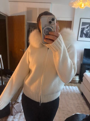 Alessa jacka vit - Supermysig vit alessa jacka med dragkedja och stor fluffig huva. Jackan är ribbad i ärmslut och midja, har en croppad passform och är perfekt för kalla dagar. Materialet känns mjukt och värmande, och den ljusa färgen gör den extra fräsch. Fick den i julklapp förra året men det är inte riktigt min stil längre vilket är synd eftersom den är så skön och så snygg!!! Använt endast i torra väder så den har aldrig blivit utsatt för regn eller något blött. Mycket bra skick🩷Nypris 1800.
