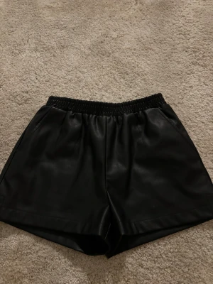 Svarta skinnshorts Designers Remix - Snygga svarta shorts från Designers remix.Aldrig andvända