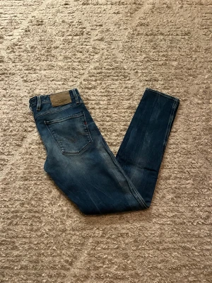 Replay Anbass jeans - Hej jag säljer ett par Replay Anbass jeans i riktigt snygg mörkblå färg perfekt för dig som vill ha ett par kvalitetsjeans med grym passform, jeansen är även i stretch material så otroligt bekväma. Nypris ≈ 1700kr, mitt pris 399kr. Skick: 9/10 Storlek: W31L34 Midja: 43cm Lår: 24cm  Ytterlängd: 106cm Innerlängd: 80cm. Skriv gärna om du vill ha fler bilder eller har frågor!