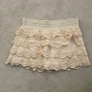 Beige shorts med volang och spets - Supersöta beige shorts med bred resår i midjan och flera lager volang i spets. 