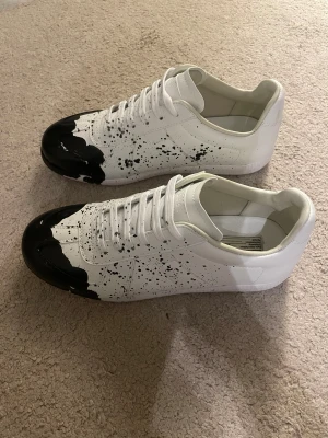 Maison margiela skor - Tja säljer nu dessa extremt snygga vita skorna med svart stänk ifrån Maison Margiela i storlek 42 för endast 2999kr! Endast skorna medföljer | priset är ej hugget i sten! Skriv i dm vid funderingar!🙌