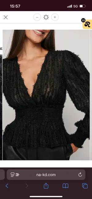 Säljer en svart omlottblus från NA-KD med transparenta långärmar och fluffig textur. Blusen har djup v-ringning, smockad midja och volang nedtill. Så fin festtopp💕💕
