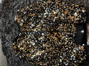 Svart bomberjacka med paljetter från Zara - Säljer en svart, tuff bomberjacka från Zara Kids, täckt med glittriga guldpaljetter. Jackan har dragkedja framtill och ribbade muddar vid hals, ärmslut och nederkant. Perfekt för ditt barn som vill sticka ut och glänsa lite extra.