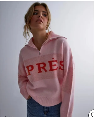 Nyskick Rosa stickad half zip-tröja från Pieces / Nelly  Stl xs  - Superfin rosa stickad tröja från Pieces med röd text 'APRÈS' över bröstet. Tröjan har en halv dragkedja, bred krage och långa ärmar. Oversized fit och ribbade muddar vid ärmslut och nederkant. Perfekt för kalla dagar och chill vibes. Köpt på Nelly . Använd en gång 