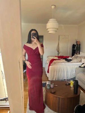 Vinröd långklänning från Goddiva - Elegant vinröd långklänning från Goddiva London. Klänningen har offshoulder-modell med v-ringning och figurnära passform. Materialet är mjukt och stretchigt