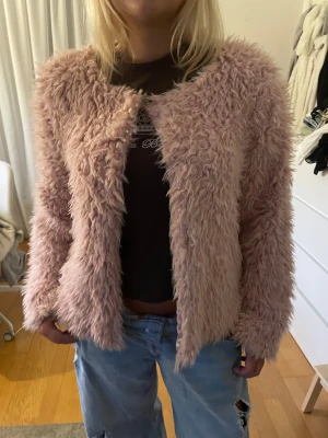 Babyrosa fuskpäls jacka - Fluffig fuskpäls rosa jacka köpt på Sellpy, har enstaka fläckar inuti som syns på de två sista bilderna! Storlek XL men är rätt liten i storleken! 