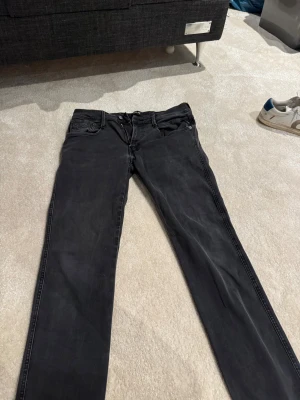 Replay Hyperflex svarta jeans.      W-33 L-32.   5 - Svarta Replay Hyperflex jeans med klassisk femficksdesign och snygga detaljer på bakfickorna. Stretchigt material för extra komfort och smal passform. Perfekt för dig som gillar stilrena och moderna jeans med lite edge.