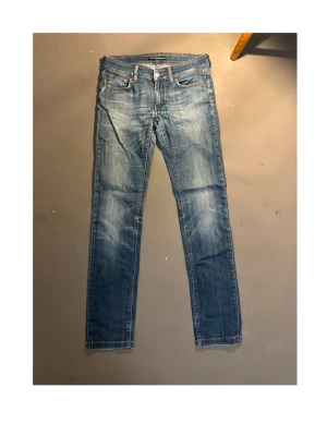 Blå jeans - Snygga blå jeans från Drykorn med klassisk femficksdesign och raka ben. Jeansen har en cool detalj med stjärnmönster på insidan av linningen och kontrastsömmar. Passar dig som gillar en stilren look med lite edge.