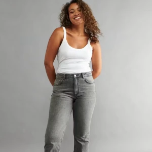 Grå raka jeans från Gina Tricot! - Snygga grå jeans från Gina med raka ben och klassisk femficksmodell. Jeansen har mellan midja och är tillverkade i mjukt denimtyg med en lätt classical look. Perfekta för dig som gillar en avslappnad men stilren vibe.