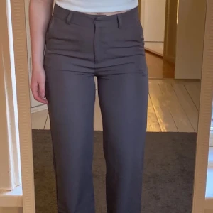 Ljusgrå kostymbyxor med raka ben - Snygga ljusgrå kostymbyxor med låg midja och raka ben, densamma som första bilden men färgen matchar den andra bilden (lånad bild) från Madlady med prislapp på! Stl 32 men skulle säga de är en 34/xs/s