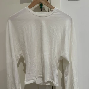 Vit långärmad basic tröja XS - Enkel och stilren vit långärmad tröja från 157 i storlek XS. Tröjan har rund halsringning och är gjord i mjuk bomull, perfekt för lager-på-lager eller som den är. Passar dig som gillar minimalistisk stil.