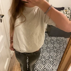 Vit basic t-shirt med rund hals - En enkel vit t-shirt med rund hals och korta ärmar. Modellen är klassisk och har en normal passform som sitter snyggt på kroppen. Materialet känns mjukt och bekvämt, perfekt till jeans eller shorts. T-shirten är helt utan mönster och detaljer.