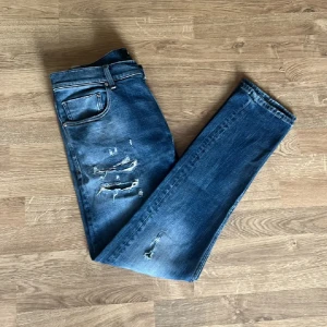 Blåa replay jeans med slitningar  - Tjenare! Säljer dessa asfeta replay jeansen med slitningar från replay. Storlek W32 L32. Model MICKYM Slim taperd fit. Skick 8/10 då en slitning i knät har gått upp men som är enkel att bara sy igen. Hör av dig om du har frågor eller funderingar🤗