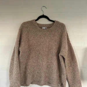 Beige fluffig stickad tröja Name It - Supermjuk och fluffig beige stickad tröja från Name It. Skulle säga att den är väldigt oversize så passar allt mellan XS-M beroende på hur man vill att den ska sitta.☺️Tröjan har rund halsringning och långa ärmar, perfekt för lager på lager under kyliga dagar. Enkel och stilren design som är lätt att matcha med allt.