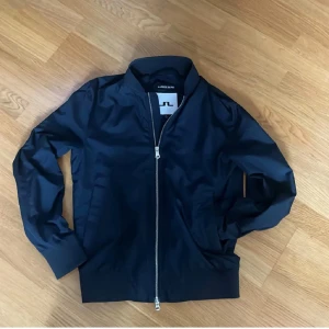 J.lindberg jacka  - Snygg mörkblå bomberjacka från J.Lindeberg, fullzip samt innerfickor. Skriv om du har fler frågor! (2 små defekter, bild vid förfrågan!)
